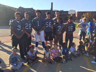 Lincoln High School football players pose with elementary students
